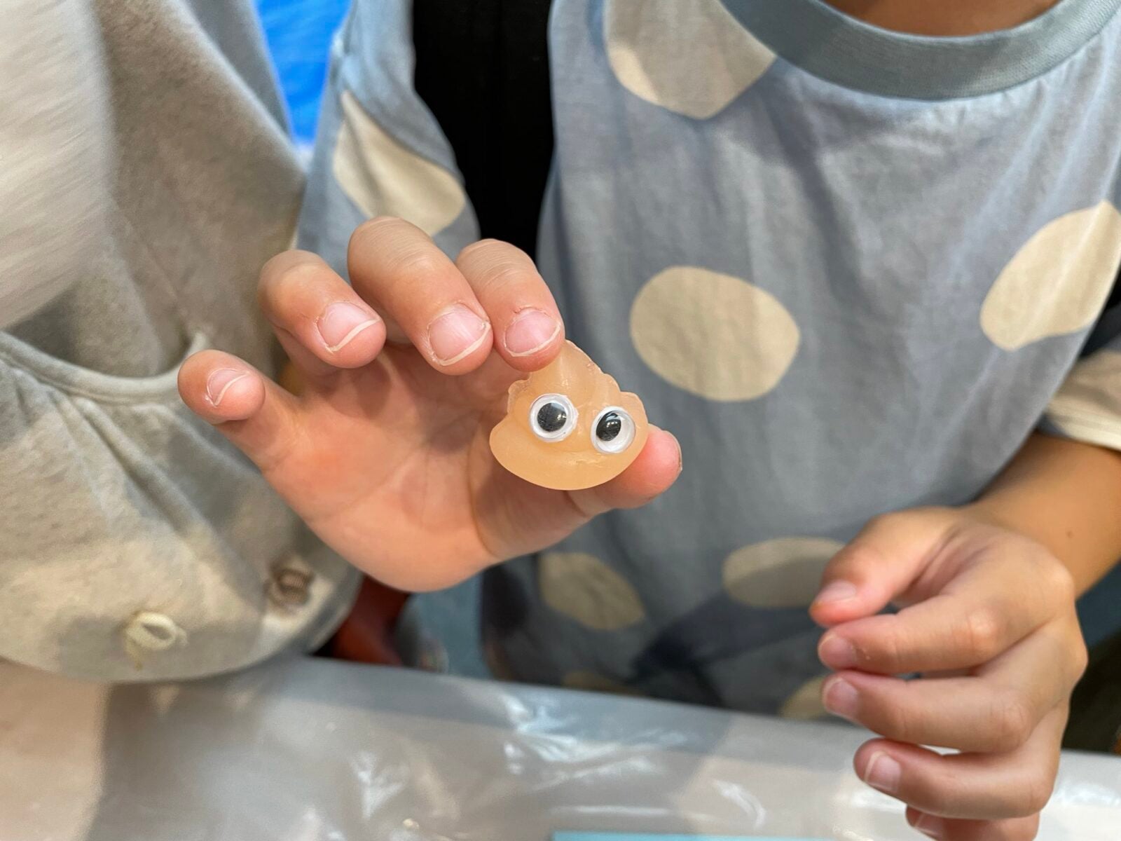 ウンチのかたちの石鹸を持った子供の写真